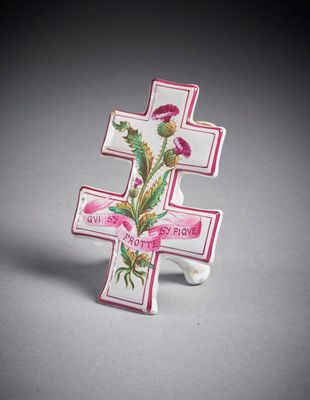 un gros plan d'une croix ornée d'une fleur