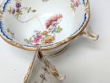 a cup and saucer sitting on a white table