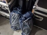 two bags of luggage sitting next to a stack of suitcases
