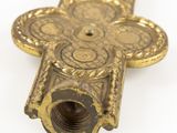 brass cross on a white background with a hole in the middle