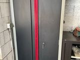un tuyau rouge qui dépasse de la porte d'une armoire métallique