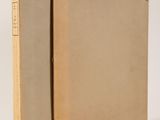 an open book with a brown cover sitting on top of a white surface