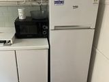 a small kitchen with a white refrigerator and a black and white stove