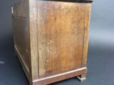 a small wooden box on a stand on a black background