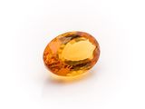 a yellow sapphire stone on a white background