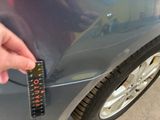a hand that is holding a sticker on the side of a car
