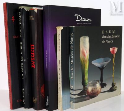 three books on a white table with a vase and a vase on it