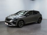 Une voiture grise est garée dans une pièce aux murs blancs.