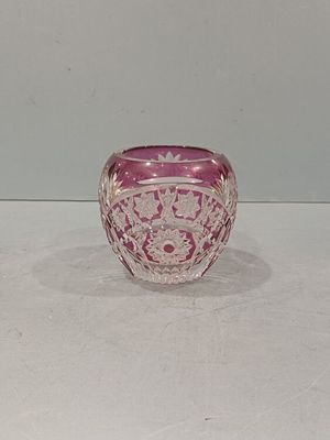 un saladier en verre rose posé sur une table blanche