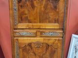 une photo d'une armoire en bois dans une pièce aux murs rouges