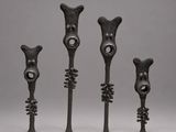a group of four metal sculptures of different shapes and sizes