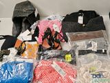 de nombreux sacs contenant des vêtements et des chaussures posés sur une table