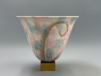 un vase rose et bleu orné d'une plume