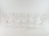 six clear wine glasses sitting on top of each other on a white surface