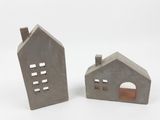 deux petites maisons en béton situées l'une à côté de l'autre sur une surface blanche