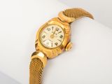 une image d'un gros plan d'une montre-bracelet sur une surface blanche