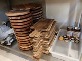 une pile de plateaux en bois posés sur une étagère dans une cuisine