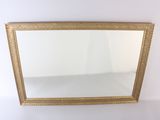 gold framed mirror on a white wall with a white background