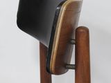 the back of a chair with a black leather seat and wooden legs