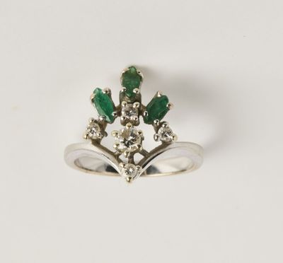 un gros plan d'une bague ornée de pierres vertes