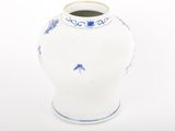 a white vase with blue designs on it on a white surface
