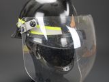 clear face shield with yellow tape on it on a black surface