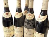 six bouteilles de vin sont alignées sur une surface blanche