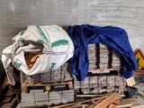 un tas de bois posé par terre à côté d'un tas de palettes