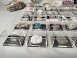 many different types of rocks and crystals in a display case