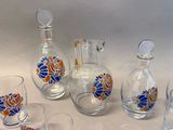 bottles and glasses are lined up on a table with a white background