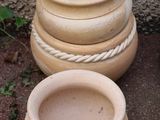 trois pots en terre cuite posés les uns à côté des autres par terre