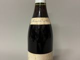 an old bottle of wine sitting on top of a table