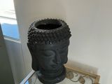 a small glass table with a buddha head on top of it