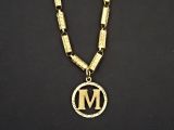 un gros plan d'un collier orné d'une lettre « m »