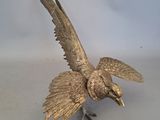 un oiseau en bronze posé sur une table