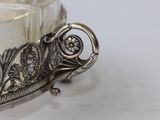 a silver bowl with a handle on a white table