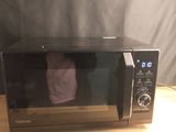 un micro-ondes posé sur une table recouverte d'une serviette