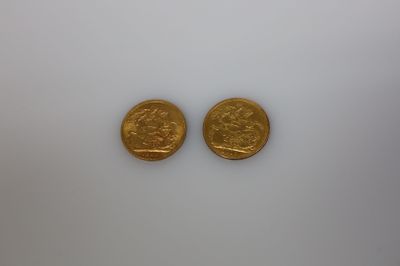Deux pièces d'or sont représentées sur une surface blanche
