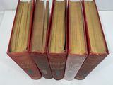 five books are stacked on top of each other on a white surface