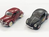 two toy cars sitting next to each other on a white surface