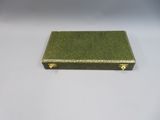 a small green box with a gold handle on a white surface