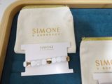 a white bag with a gold ring and a white bag with a gold ring on it