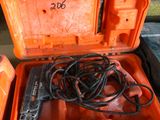 une boîte à outils orange contenant un cordon d'alimentation et une perceuse