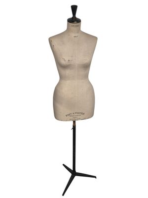 un mannequin posé sur un socle noir, avec un fond blanc