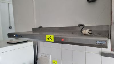 un chat assis sur une étagère dans la cuisine