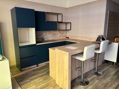 a kitchen with a counter and chairs in it