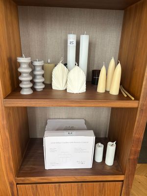 a wooden shelf with candles, vases, and other items on it