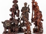 quatre figurines sculptées représentant des personnages et des animaux sur un fond blanc