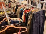 beaucoup de vêtements suspendus à une étagère dans un magasin