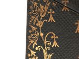 a black and gold case with gold designs on it